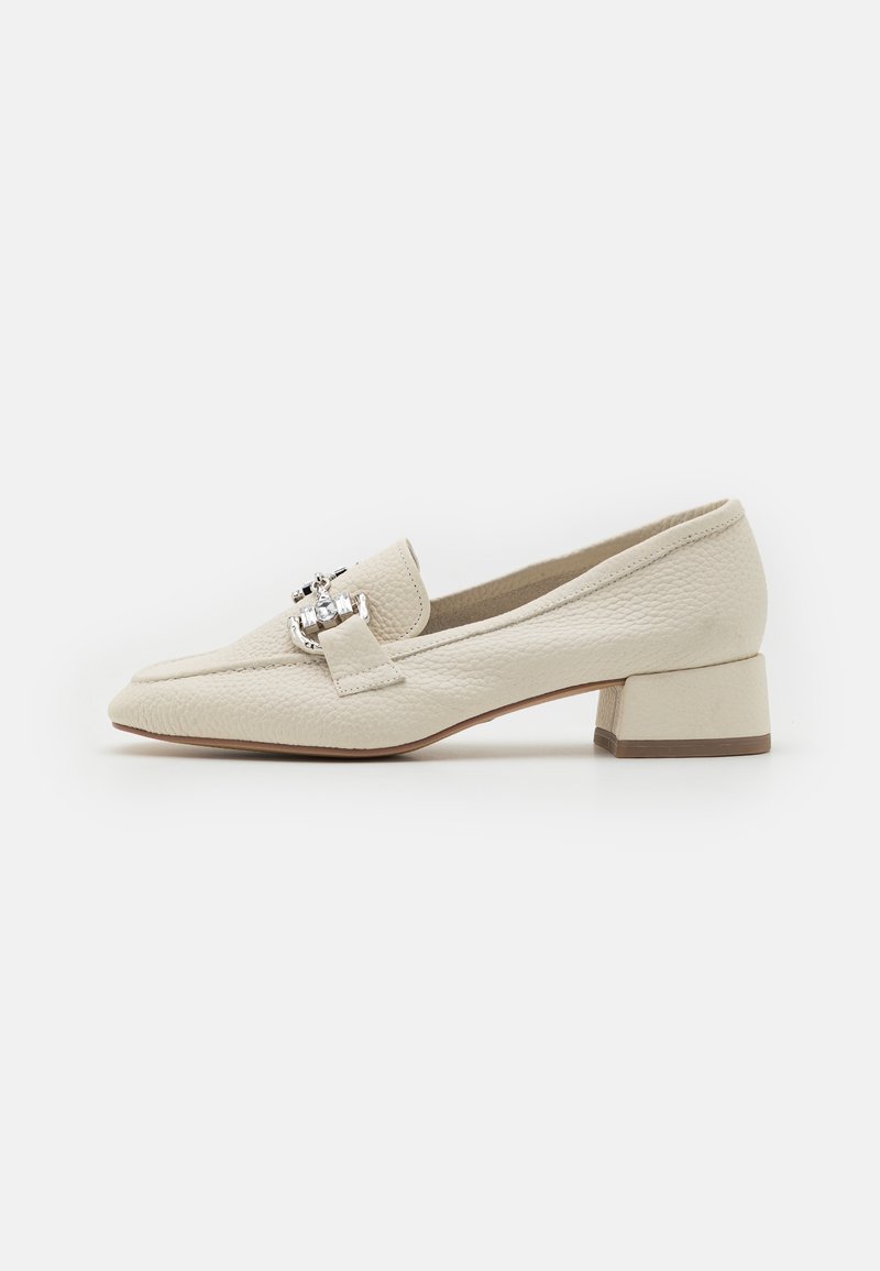 Mocassin en cuir blanc cassé à petit talon avec détail de boucle argentée et finition texturée, vue latérale sur fond blanc.