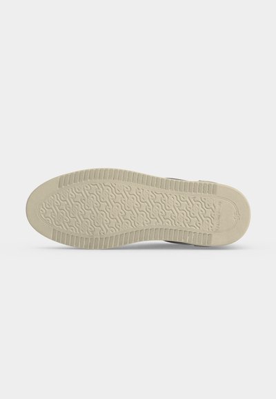 Semelle de chaussure beige avec un motif de bande de roulement texturé comprenant des lignes courbes et des zones d’accroche rectangulaires sur les bords.