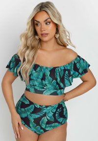 Bikini-set med avstående axlar som har ett lövigt grönt mönster på svart bakgrund, med volangdetaljer och högmidjade underdelar.