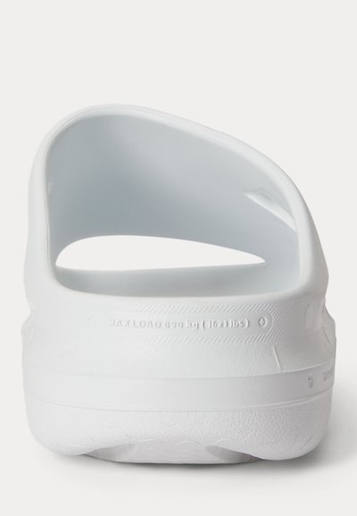 Λευκό σανδάλι τύπου κλογκ με στρογγυλεμένο λουράκι στη φτέρνα και υφή στην σόλα, εμφανιζόμενο από πίσω σε λευκό φόντο.