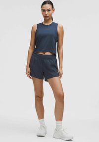 Temno modra atletska majica brez rokavov s skrajšanim dizajnom in detajlom logotipa, v kompletu z ujemajočimi se kratkimi hlačami z elastičnim pasom.
