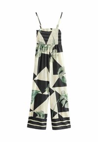 Combinaison sans manches à jambes larges avec corsage froncé, motif géométrique noir et crème, accents de feuilles vertes et fines bretelles.