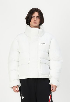Hvid puff jakke med høj krave, forsiden er forsynet med lommer, og der er et logo på brystet; har en quilted struktur og en boxy silhuet.