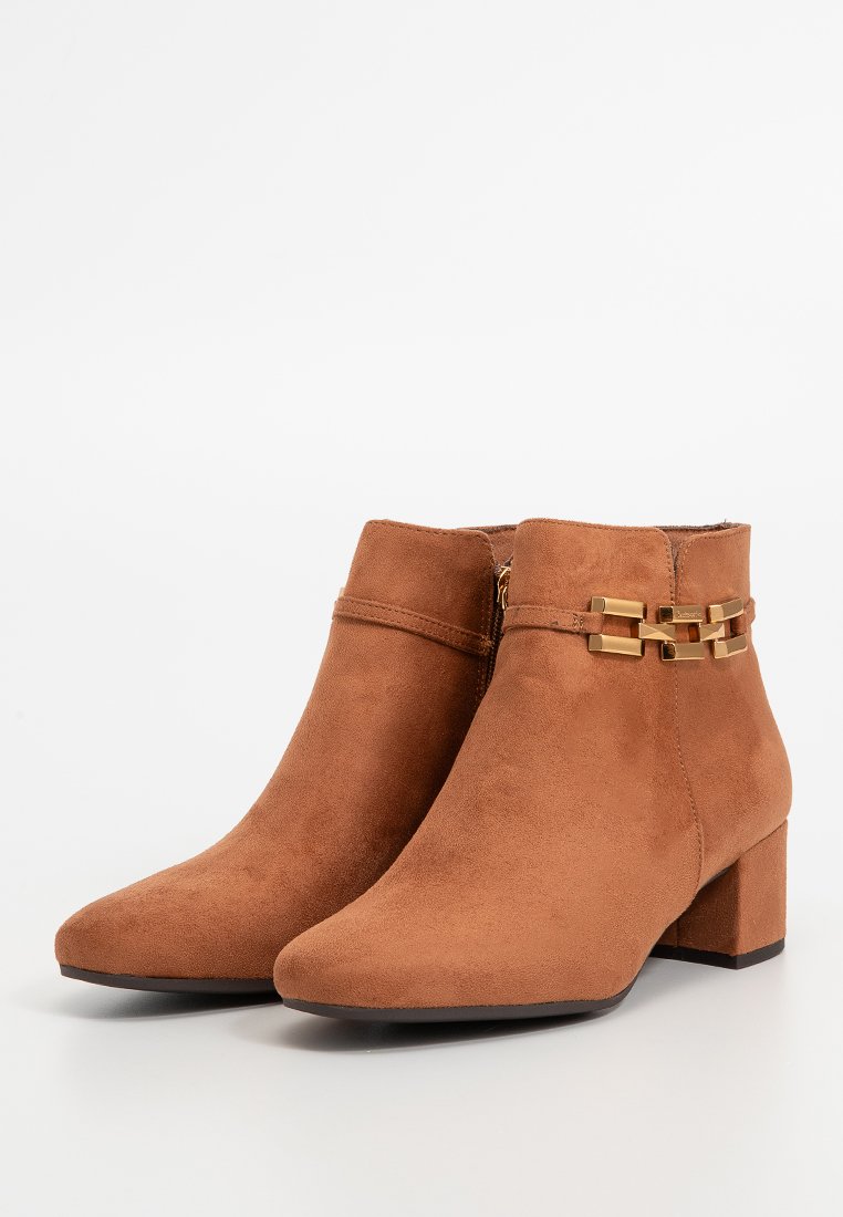 Braune Wildleder-Ankle-Boots mit spitzem Zehenbereich und Blockabsatz. Mit einem goldenen Kettenakzent und einem seitlichen Reißverschluss zum Schließen.