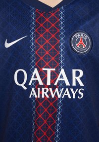 Mornaričasti drešč s rdečim in modrim geometrijskim vzorcem, ki ima bel Nike logo, napis "QATAR AIRWAYS" in emblem PSG na prsih.