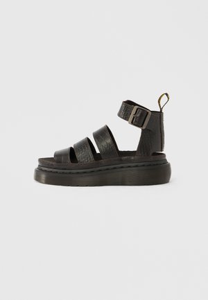 Sandales en cuir noir avec trois larges brides, une bride de cheville à boucle et une finition texturée. Semelle plateforme épaisse avec des détails côtelés.