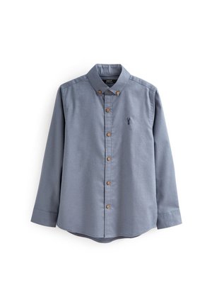 Long-sleeve button-up shirt in light blue cotton fabric. Features brown buttons and a small embroidered design on the left chest.