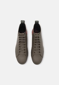 Kotníkové tenisky z texturované olivově zelené kůže, se šněrováním na ploché tkaničky, kontrastními červenými detaily a poutky pro snadné nazouvání.
