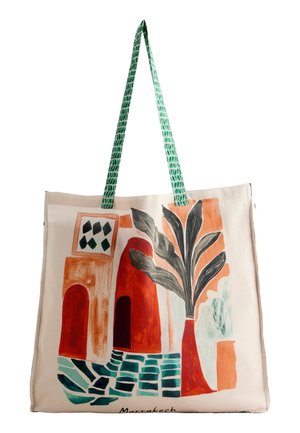 Taška na rameno so zelenými vzorovanými rúčkami, na ktorej sú abstraktné oranžové budovy, veľká rastlina so sivými listami a zelená dlažba na zemi s nápisom „Marrakech“.