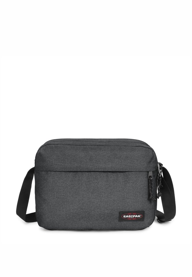 Sac à épaule en tissu gris avec une forme plate et rectangulaire, doté d'une seule sangle réglable et d'une poche zippée à l'avant. Logo Eastpak visible.