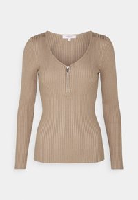 Langsmouwen, geribbelde top in een lichtbeige kleur met een diepe V-halslijn en een korte rits aan de voorkant. Zachte, rekbare stof.