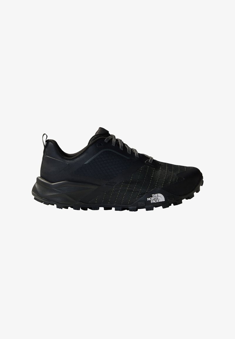 Black trail running shoe with a textured mesh upper, rubber outsole, and contrasting accents. Features an agile design for outdoor activities.