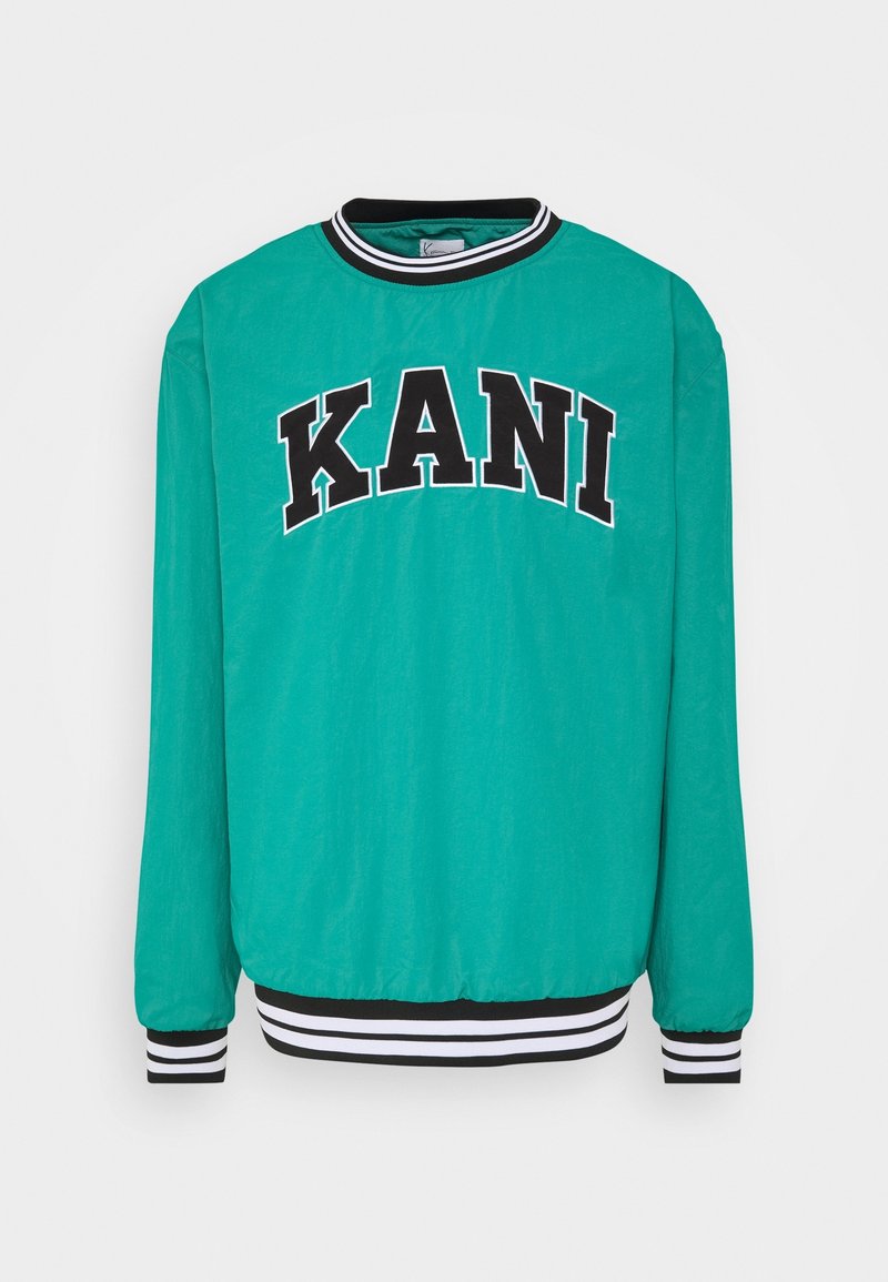 Pull-over à manches longues couleur bleu sarcelle avec poignets et col rayés noirs et blancs, arborant en lettres noires audacieuses le mot "KANI" sur la poitrine.