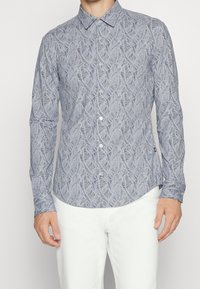 Blauw overhemd met lange mouwen en een bladpatroon, voorzien van een button-downkraag en een afgeronde zoom, gemaakt van lichtgewicht stof.