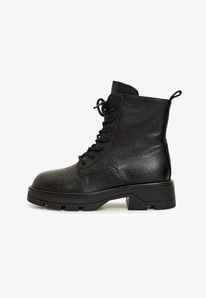Sorte ankelstøvler lavet af struktureret læder, med snørebånd, rund tå og en solid blokhælhæl med en løkke bagpå.