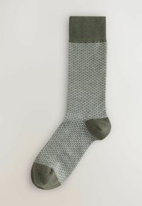 Calcetín con un patrón verde y gris, con un puño acanalado, puntera reforzada y un diseño de punto texturizado, que presenta un talón y puntera de color verde sólido.