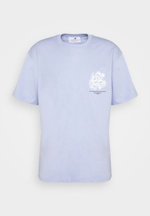 Light purple short-sleeve T-shirt with graphic, paired with oversized beige cargo pants and black lace-up boots. Smooth fabric and relaxed fit.