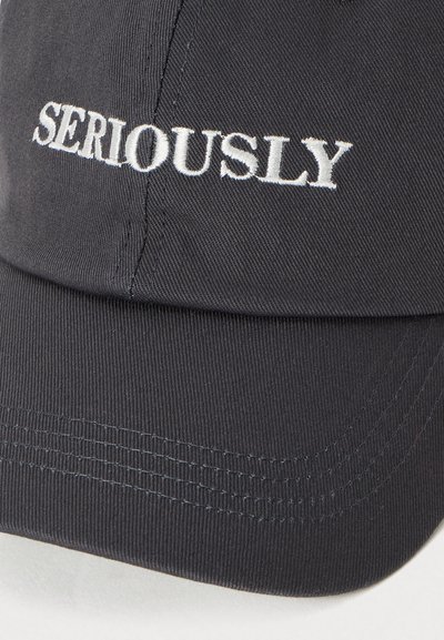 Casquette de baseball noire avec le texte brodé en blanc "SERIOUSLY" sur le panneau avant, montrant des coutures visibles sur la visière.