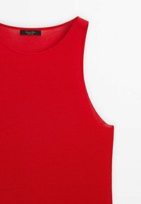 Czerwony, żebrowany top na ramiączkach z okrągłym dekoltem i szerokimi wycięciami na ramionach. Wykonany z miękkiego, elastycznego materiału dla wygody. Metka widoczna przy szyi.