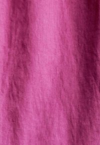 Tissu rose avec texture visible et plis naturels, montrant des variations subtiles de couleur et un motif doux tissé.