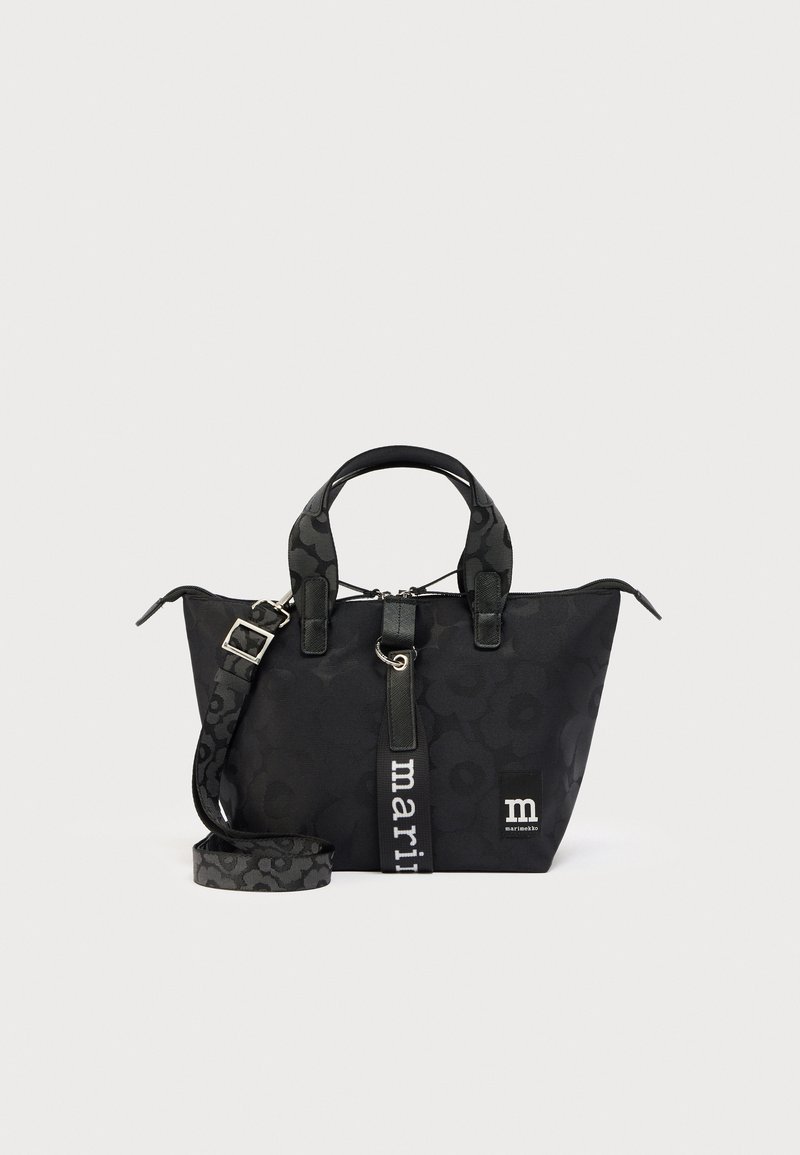 Μαύρη τσάντα ώμου με σχέδια, διπλές λαβές, ρυθμιζόμενο λουρί, κάθετη υφασμάτινη ταμπέλα με την επιγραφή "marimekko" και μικρό έμβλημα λογότυπου της μάρκας.