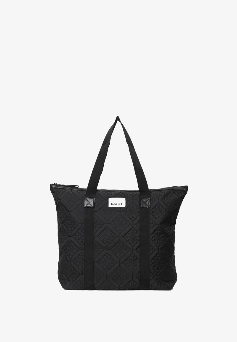 Svart kviltad tote-väska med två kraftiga remmar, dragkedja och en vit märkesetikett. Diamantmönster präglat på materialet.