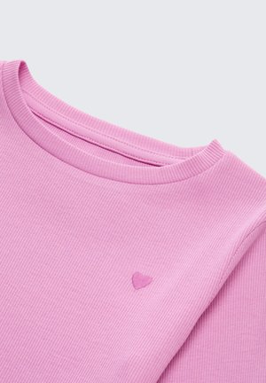 Maglietta a maniche lunghe rosa a coste con scollatura rotonda e un piccolo dettaglio ricamato a forma di cuore sul petto, che mostra un tessuto testurizzato.