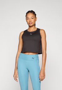 Black cropped tank top with a round neckline and sleeveless design, paired with light blue high-waisted leggings featuring a logo.