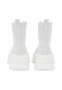 Botines de ante blancos hasta el tobillo con una suela de goma blanca gruesa, que cuentan con un acabado suave, lengüetas y costuras de contraste a lo largo de las costuras.
