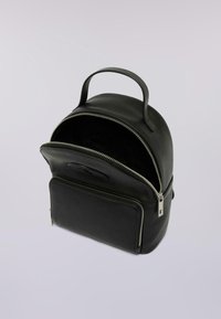 Kleiner schwarzer Leder-Rucksack mit Obergriff, schneller Vorderfachtasche und offenem Hauptfach, das das dunkle Innere vor einem weißen Hintergrund zeigt.