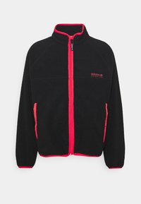 Černá fleecová bunda na zip s růžovými akcenty. Má vysoký límec, přední zip a boční kapsy. Na levém prsu je vyšívané logo.