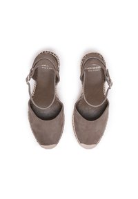 Brown suede espadrilles with a rounded toe, ankle strap, and woven jute sole. Features contrasting stitching around the sole edge.