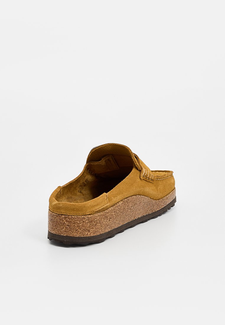 Chaussure slip-on en daim marron avec une semelle en liège et une semelle extérieure en caoutchouc texturé noir, vue de l'arrière sur un fond blanc.