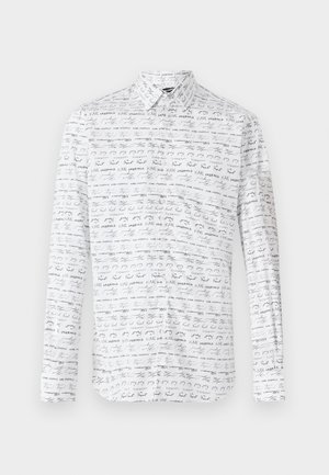 White button-up shirt featuring a repeating black handwritten text pattern. Long sleeves and classic collar. Smooth fabric texture.