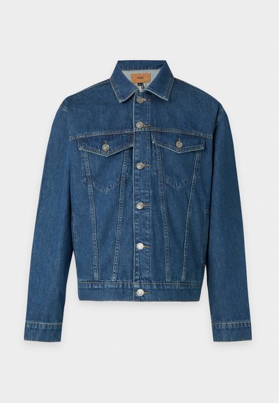 Veste en jean bleue avec fermeture à boutons sur le devant, deux poches poitrine à rabat avec boutons, et manches longues sur fond gris clair.