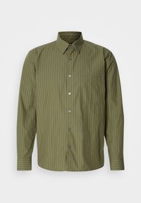 Chemise boutonnée manches longues vert olive avec fines rayures verticales et une poche poitrine gauche sur fond uni.