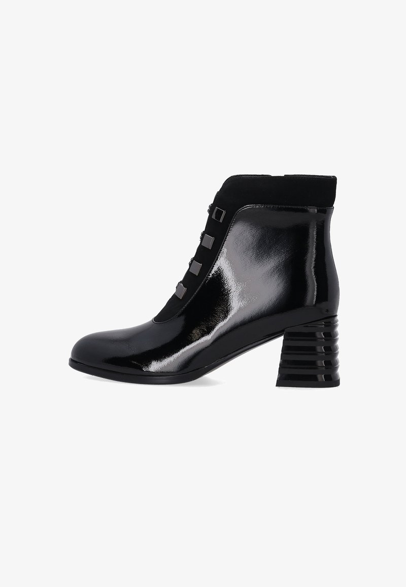 Schwarze Knöchelstiefel aus glänzendem Lackleder mit einem strukturierten Wildlederpanel. Quadratischer Blockabsatz mit vertikalen Rillen; vordere Akzentknöpfe sind sichtbar.