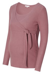 Haut de maternité en tissu côtelé rose délavé, présentant un design cache-cœur avec un détail noué sur le côté et des manches longues.