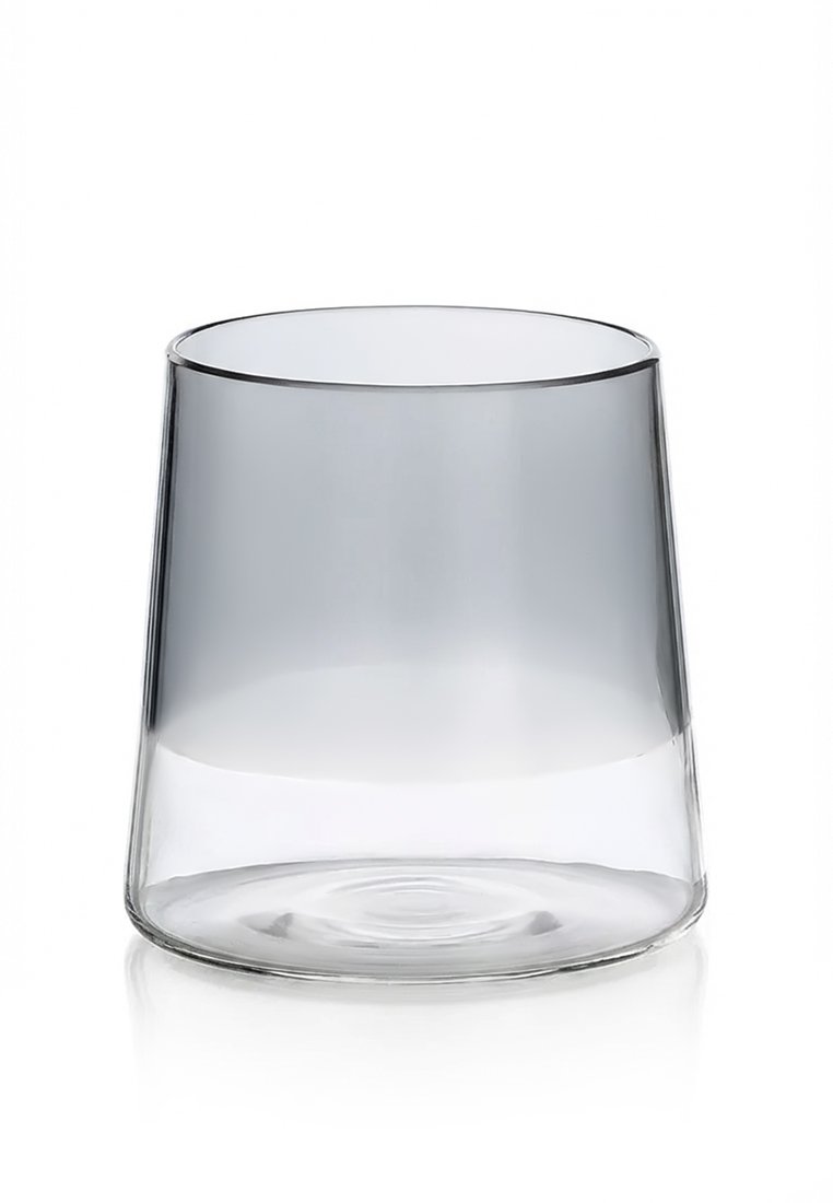 Przezroczysta, zwężana szklanka do picia z cienką krawędzią, pusta, stojąca pionowo na białej, odbijającej powierzchni.