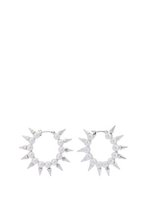 Korvarengas, jossa on vuorotellen valkoisia helmiä ja hopeisia kartiomaista piikkejä, hyvin kiillotettu hopeaklipsi. Pyöreä muotoilu, jossa on teksturoitu pinta.