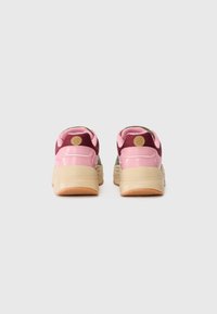 Zapatillas multicolores con parte superior en rosa y burdeos y detalles de malla. Forma redondeada con suela texturizada en beige y acentos de logo.