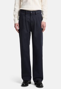 Pantaloni navy blu a gamba larga con chiusura a pulsante e passanti per cintura, realizzati in un morbido tessuto misto cotone con una leggera lucentezza.