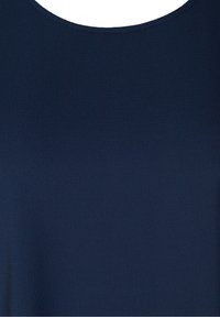 Haut bleu marine en tissu lisse et texturé ; présente un col rond et un design uni sans motifs ni accents supplémentaires.