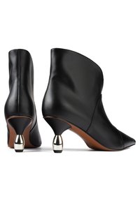 Bottines en cuir noir à bout pointu, avec des talons métalliques bulbeux et une finition lisse. Design simple avec des accents minimaux.