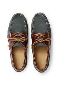 Zapatos mocasines de ante gris con detalles de cuero marrón, cordones a juego y costuras en contraste. Cuentan con una plantilla texturizada y punta redondeada.