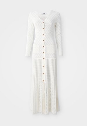 Langes weißes Strickkleid mit V-Ausschnitt und langen Ärmeln. Verfügt über große Knöpfe und zwei vordere Taschen, mit einem gerippten Muster und Design.