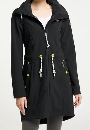 Veste noire imperméable avec un col montant, tissu texturé, accents jaunes, cordons élastiques et poches latérales avec fermeture à bouton.
