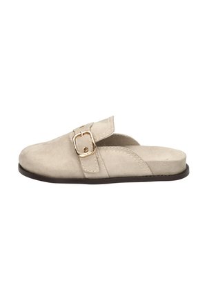 Beige suède slip-on mule met een gouden gespband en een lage zwarte zool, zijaanzicht.