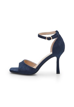 Tengerészkék velúr stiletto szandál, nyitott orral, bokapánttal és texturált felülettel. Karcsú sarok kialakítással rendelkezik.