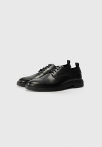 Black leather dress shoes with a rounded toe, lace-up closure, and a low rubber heel. Features a smooth texture and minimalistic design.
